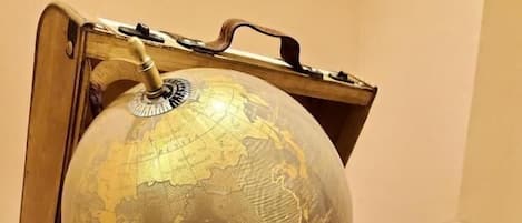 A globe on top of a stack of vintage suitcases.