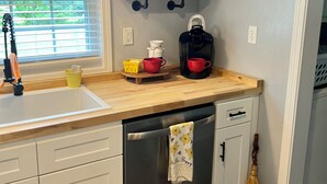 A kitchen with a wooden countertop, white cabinets, a stainless steel dishwasher, and a broom. - August special ✨99.00✨night!2B-2B cottage-hot tub-by Fall Creek Falls Park. (Spencer)