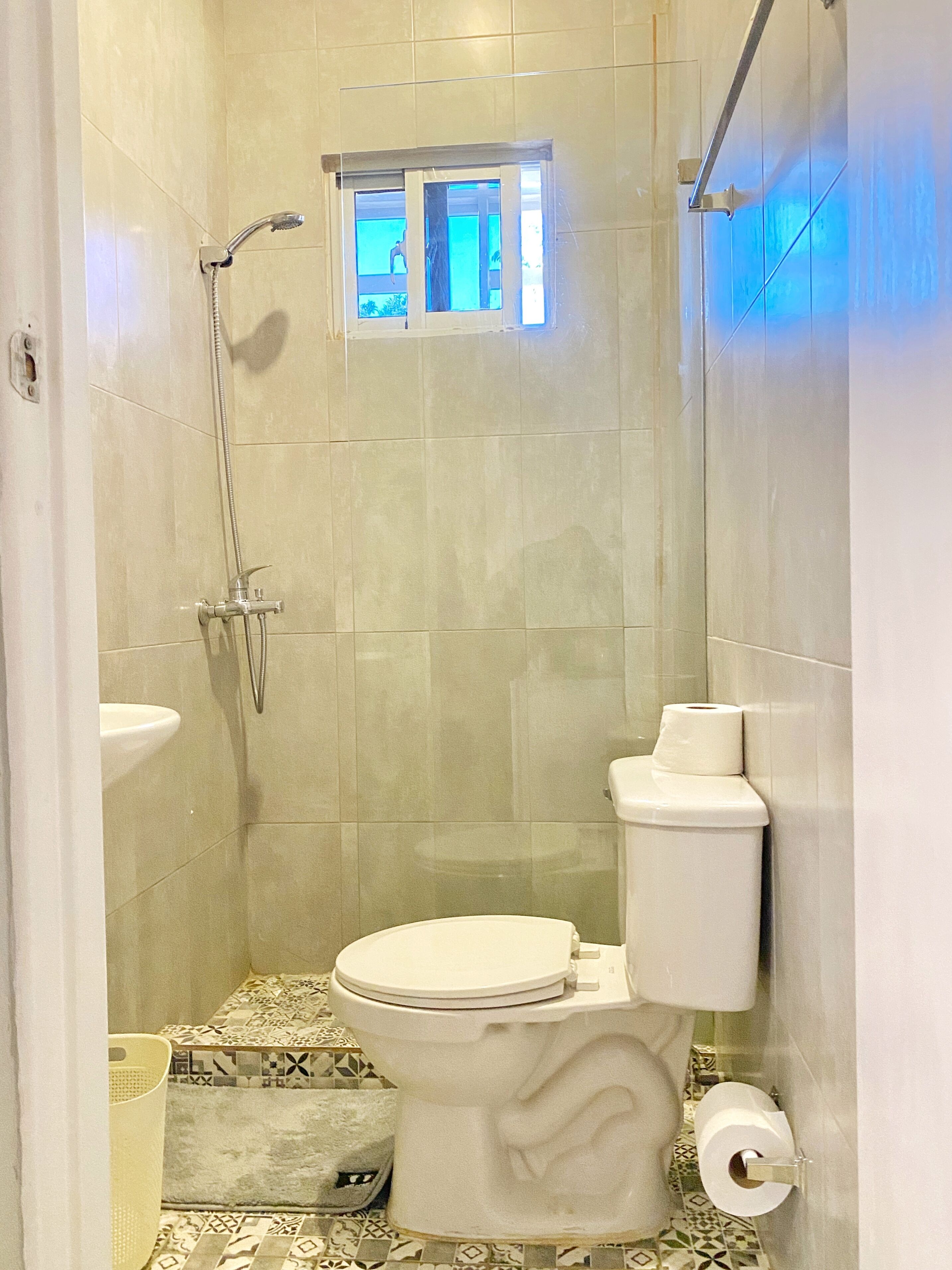 Un baño pequeño con inodoro, ducha y lavamanos.