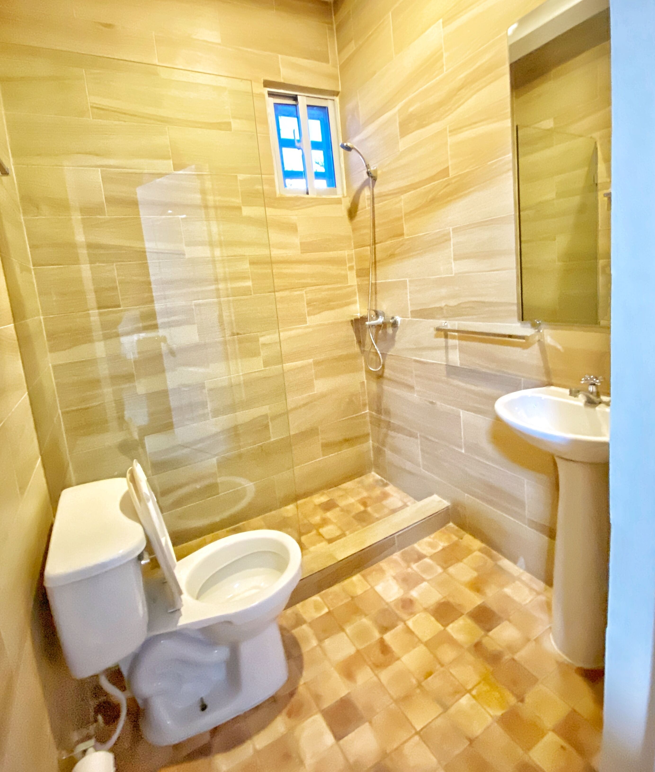 A bathroom with a toilet, shower, and sink.