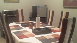 Ein Esstisch mit weißer Tischdecke, umgeben von Holzstühlen mit schwarz-weißen Mustern.