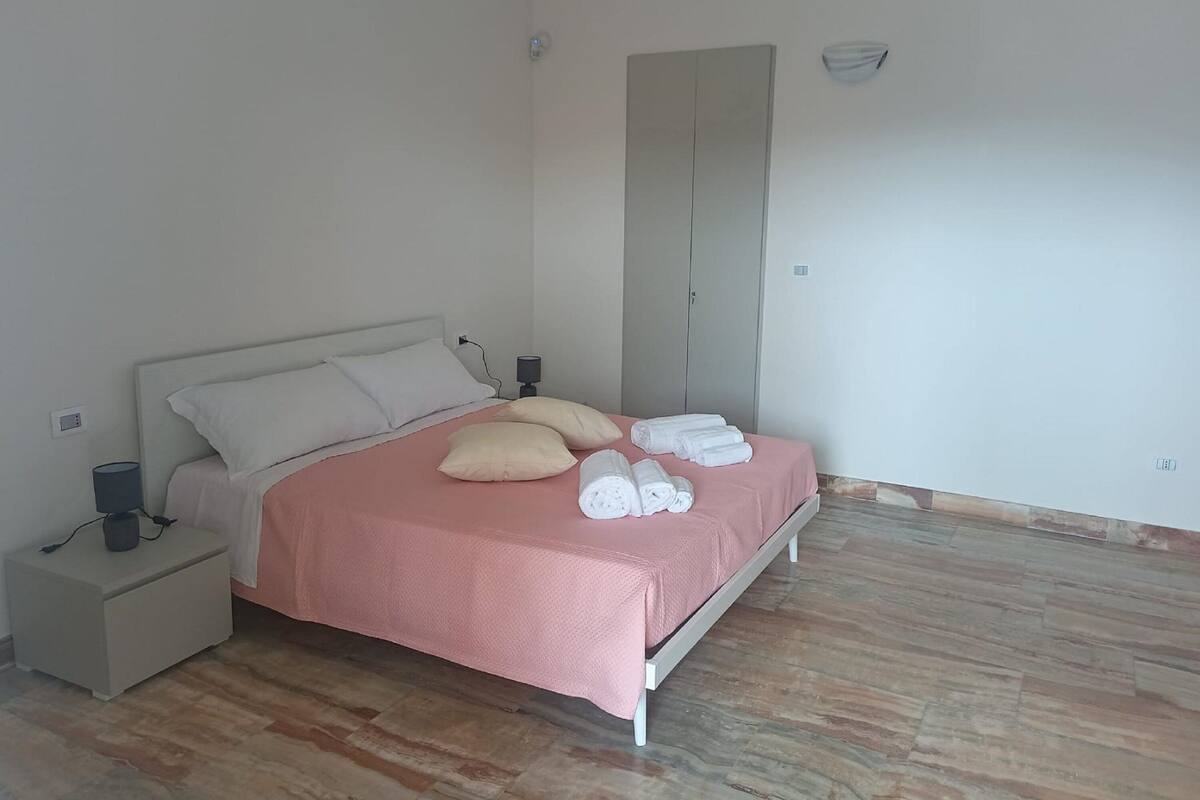 A bedroom with a bed, nightstand, and a wardrobe.