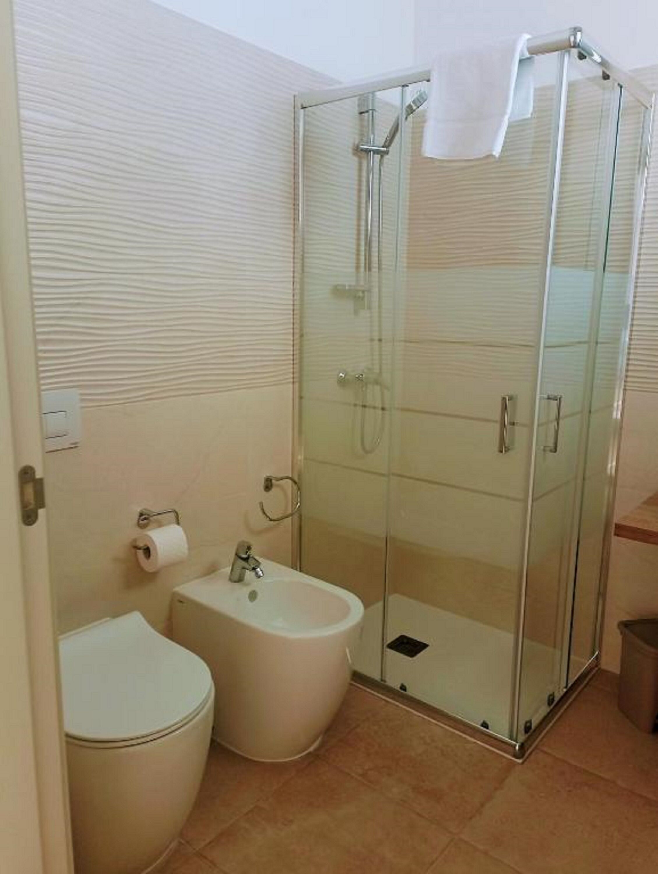 Ein modernes Badezimmer mit einer Duschkabine, einem Bidet und einer Toilette.
