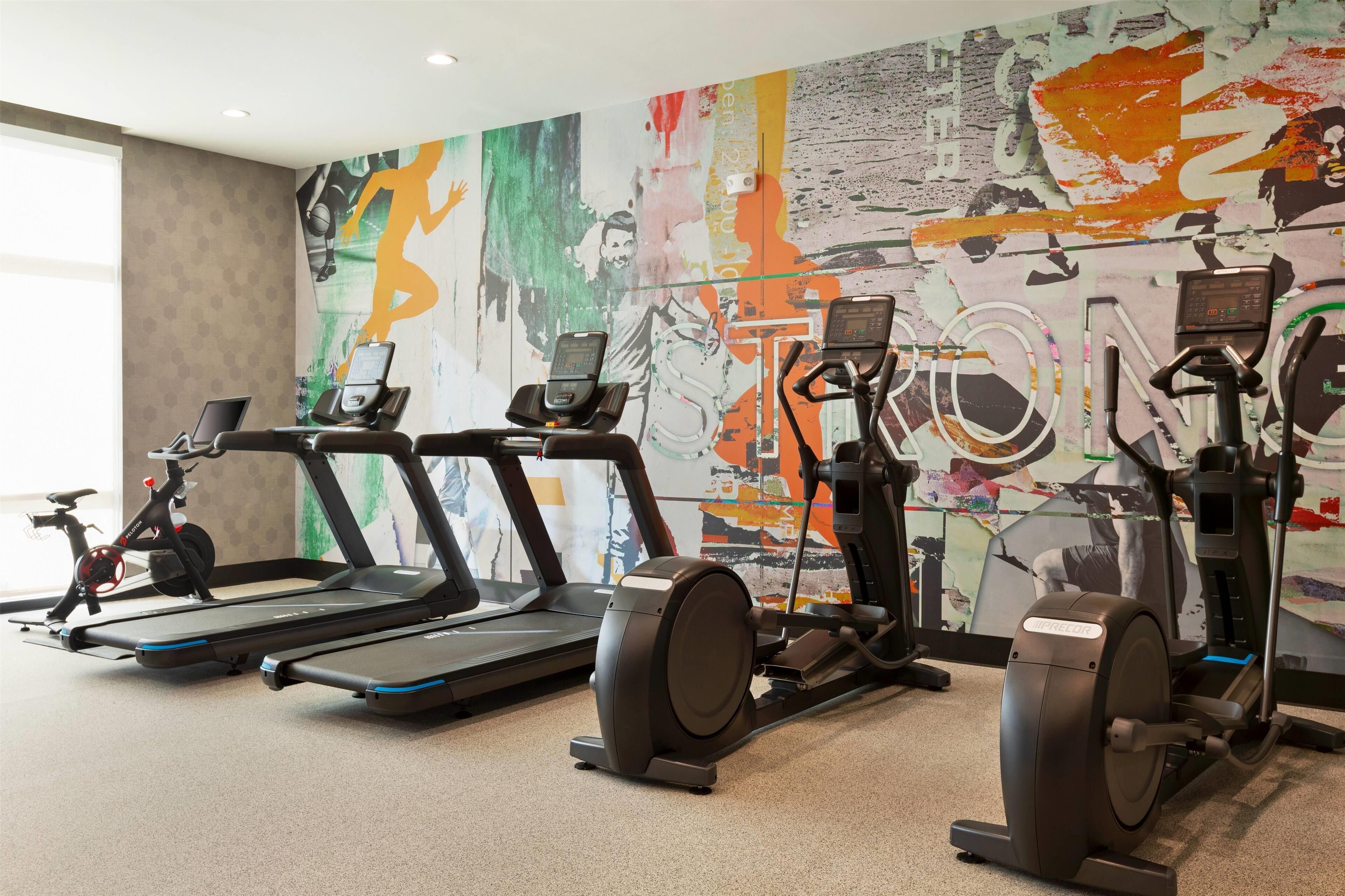 A gym with treadmills, elliptical machines, and stationary bikes.