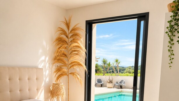 Une chambre avec un grand lit, une vue sur une piscine et un balcon.