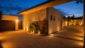 A modern building with a stone facade, a garage, and a gravel driveway.