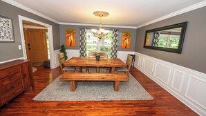 A dining room with a wooden table, benches, and a chandelier. - Large Home - Bar - Hot Tub - Private Back Yard (Louisville)