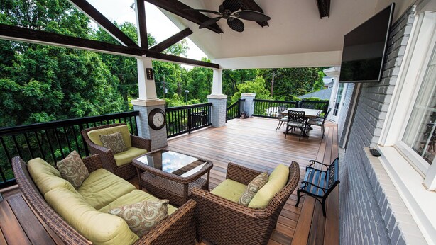 A covered outdoor patio with wicker furniture, a table, and a TV mounted on the wall. - Large Home - Bar - Hot Tub - Private Back Yard (Louisville)