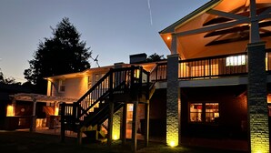 A two-story house with a covered outdoor area, a staircase, and a brick exterior. - Large Home - Bar - Hot Tub - Private Back Yard (Louisville)