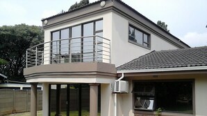 A two-story house with a balcony, large windows, and a brick exterior. - Remarkable 5-bed House in Springs & Nigel (Nigel)