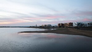 A coastal scene with a beach and buildings in the background.