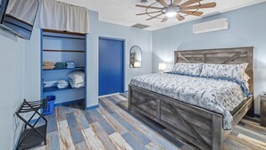 A bedroom with a wooden bed, a ceiling fan, a built-in wardrobe, and a TV mounted on the wall. - Roos&Blues lake house. City park steps away. Rm for 6, king beds, pets friendly (Madisonville)