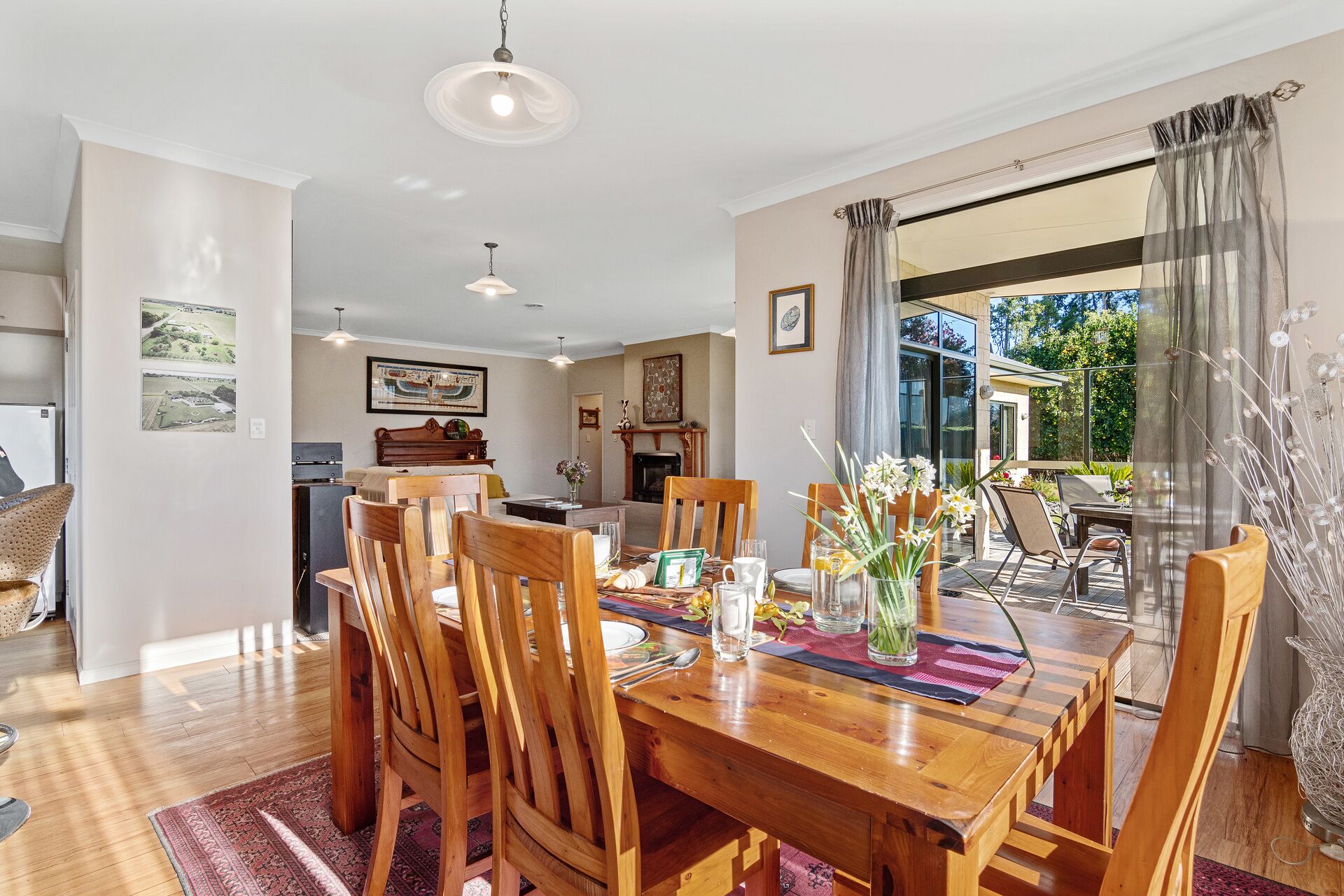 A dining area with a wooden table and chairs, a fireplace, and a view of the outdoors.