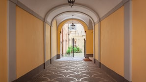 A hallway with a patterned floor, arched ceiling, and yellow walls. - Annamaria House at the Pantheon (Roma)