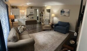 Relax in this stylish living space with a sofa, armchair, and dining area.
