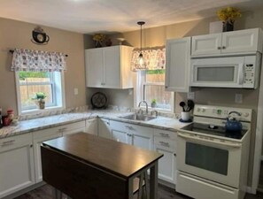 Enjoy cooking in this well-equipped kitchen with a central island, microwave, and oven.