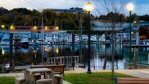 Un porto turistico con barche ormeggiate, una panchina di legno e un tavolo con sgabelli.
