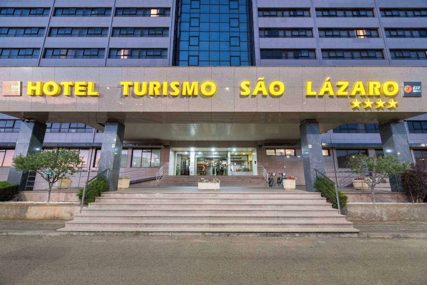 Een hotelentree met een bord waarop 'HOTEL TURISMO SÃO LÁZARO' staat en een logo dat aangeeft dat het deel uitmaakt van de 'eHotel'-keten.