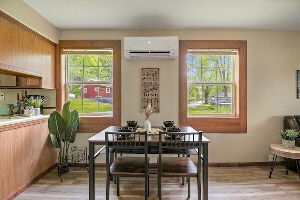 Enjoy meals in this kitchen with a dining table for four, featuring countertops and a large window.