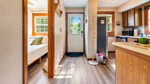 A compact kitchen with wooden cabinets, a microwave, and a refrigerator. - Fishing · Kayaks · Firepit · Paddleboat (Pierceton)