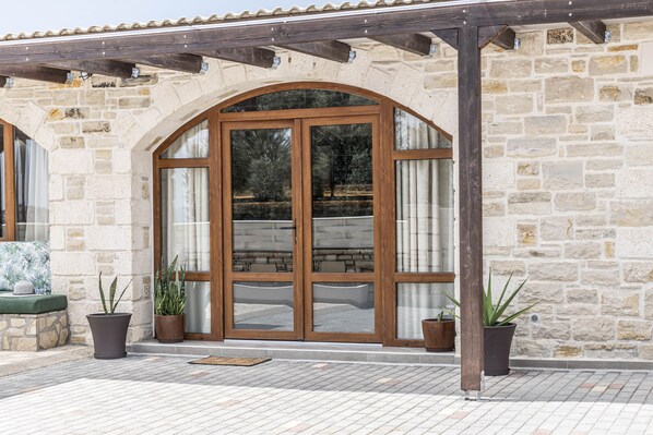 Un bâtiment en pierre avec une porte en bois et des plantes en pot.