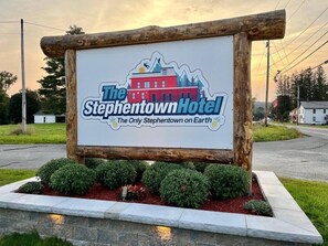 A sign for The Stephentown Hotel with a depiction of a red building and mountains.