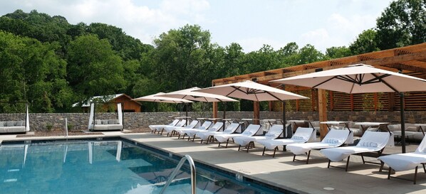 Piscine extérieure en saison, parasols, chaises longues