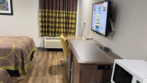 A hotel room with two beds, a desk, a microwave, and a television. - Executive Inn and Suites Baker (Baker)