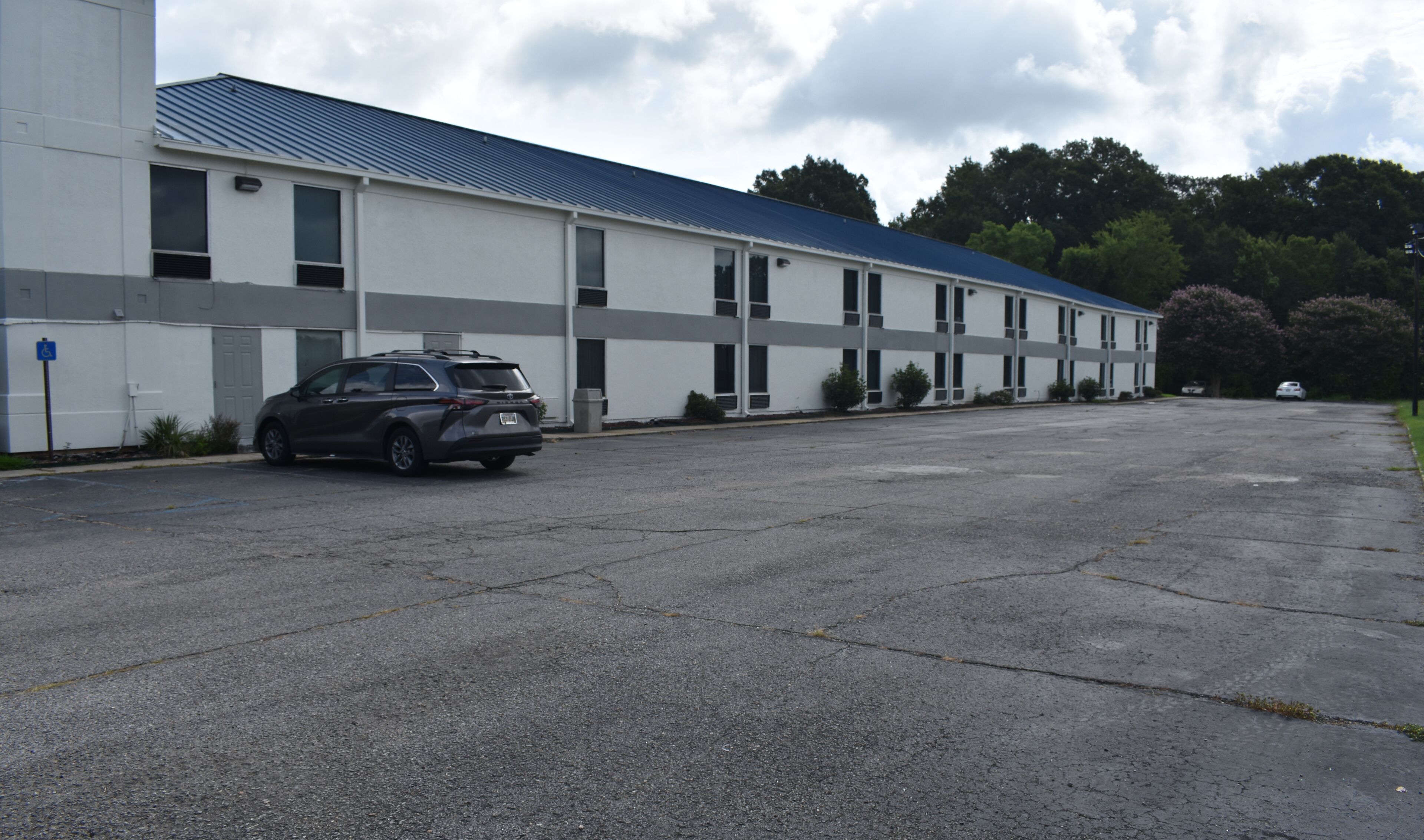 A large, single-story motel with a parking lot.