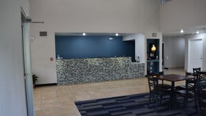 A spacious living area with a kitchen counter, dining table, and chairs. - Executive Inn and Suites Baker (Baker)