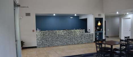 A spacious living area with a kitchen counter, dining table, and chairs.