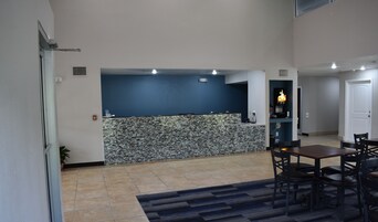 Uma sala de estar ampla com bancada de cozinha, mesa de jantar e cadeiras.