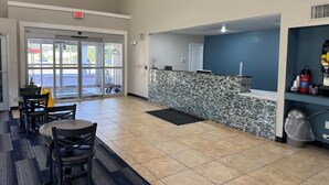 A spacious lobby with a reception desk, seating area, and a view of the parking lot. - Executive Inn and Suites Baker (Baker)