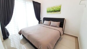 Un dormitorio con cama, cortinas, una mesita de noche y un cuadro en la pared.