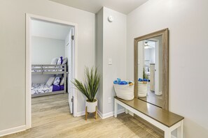 A hallway with a wooden bench, a potted plant, and a mirror on the wall. - 10 Mi to Navarre Beach! Waterfront Rental w/ Pool (Mary Esther)