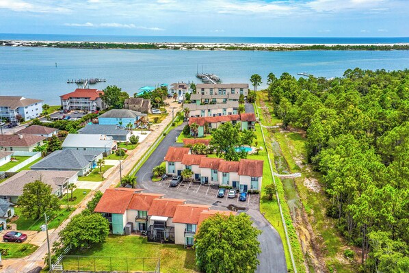 A coastal hotel with multiple buildings, a parking lot, and a view of the ocean. - 10 Mi to Navarre Beach! Waterfront Rental w/ Pool (Mary Esther)
