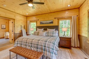 Ein Schlafzimmer einer Holzhütte mit einem Bett, einer Bank und zwei Nachttischen.