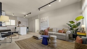 A modern living room with a sofa, coffee table, and a dining area with a bar. - La casa de las velas (Playa Honda)