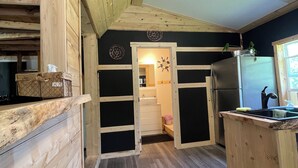 A kitchen with wooden cabinetry, a stainless steel refrigerator, and a sink.