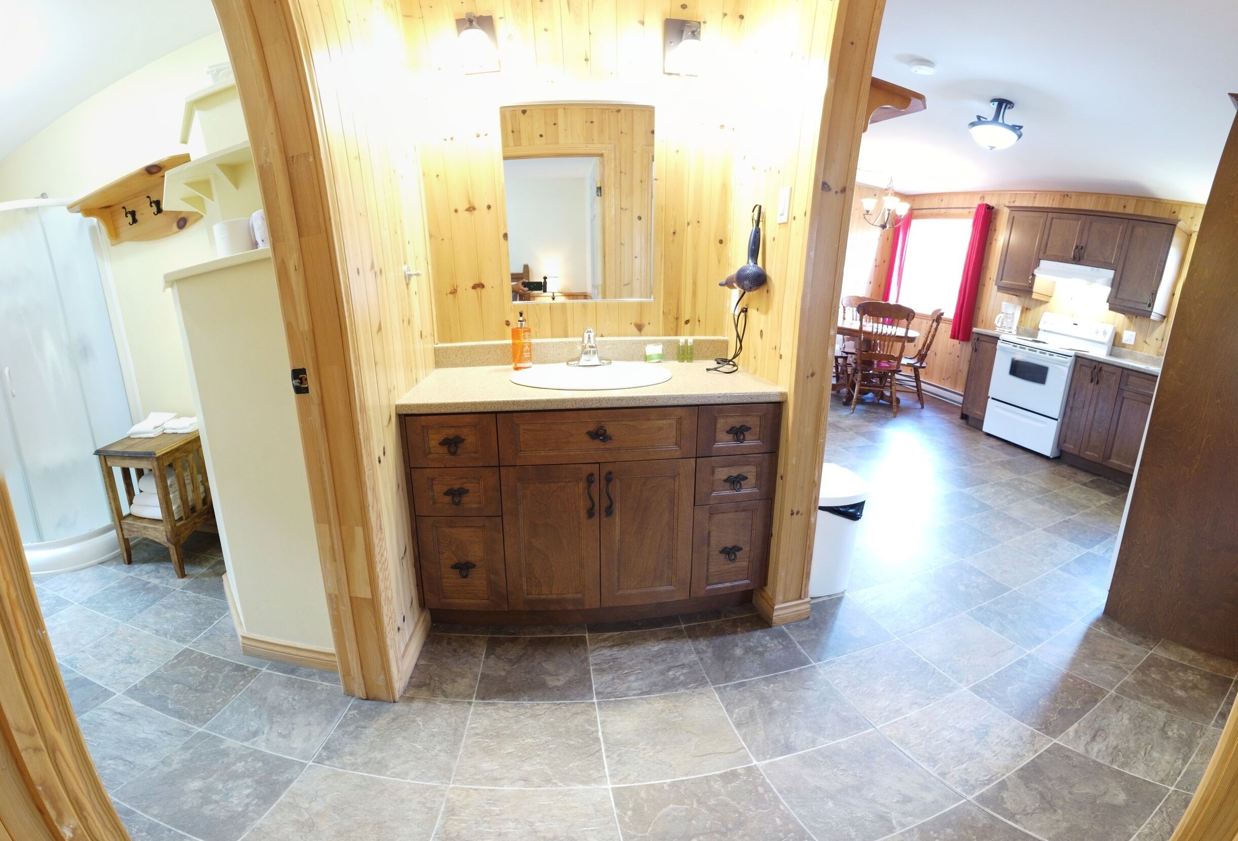 A wooden bathroom with a sink, mirror, and cabinets.