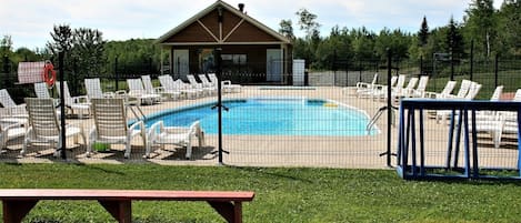 En säsongsöppen utomhuspool och parasoller