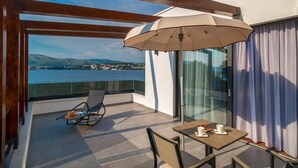 A balcony with a view of the sea, a table with cups, and a chair with a hat. - Villa Tetra - Six Bedroom Villa, Sleeps 11 (Okrug Gornji)