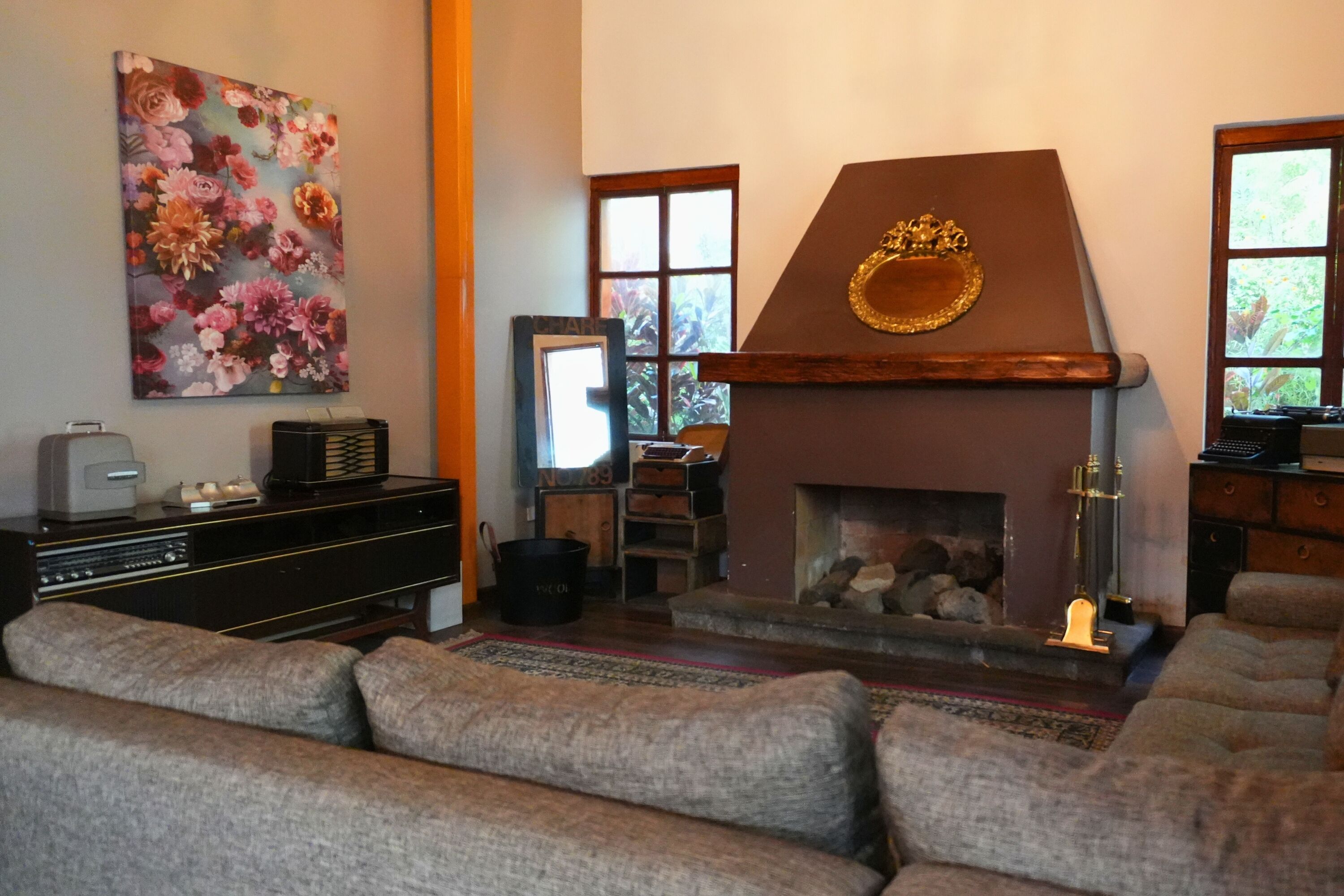 A living room with a fireplace, a sofa, a television, and a painting on the wall.
