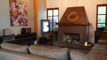 A living room with a fireplace, a sofa, a television, and a painting on the wall.