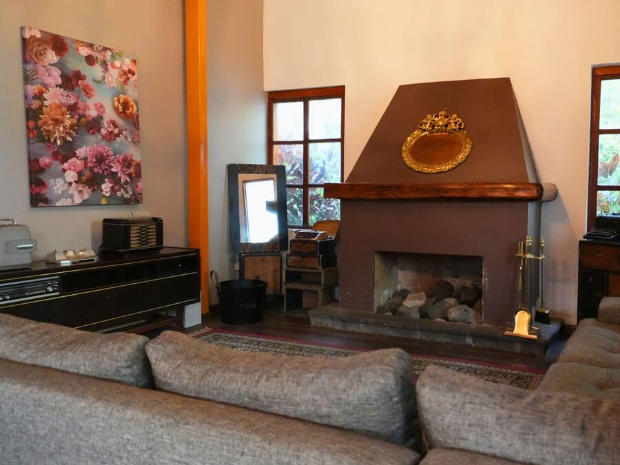 A living room with a fireplace, a sofa, a television, and a painting on the wall.