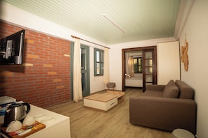 Apartamento design, 1 cama King e sofá-cama, vista para o pátio, no jardim | Sala de estar | Smart TV 82 cm com canais via satélite, TV