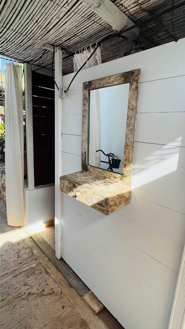 A bathroom with a wooden vanity, a mirror, and a bicycle in the reflection.