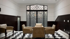 A room with a checkered floor, four beige chairs arranged around a table, and a decorative partition with geometric patterns. - 2 Minutes From Copacabana Beach Df408 (Rio de Janeiro)