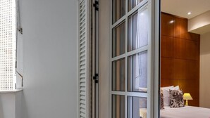 A hotel room with a sliding glass door leading to a balcony, tiled floor, and a bed with a red bedspread. - 2 Minutes From Copacabana Beach Df408 (Rio de Janeiro)