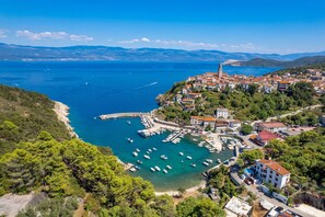A coastal town with a marina, buildings, and a prominent tower.
